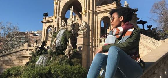 An SU student sitting on a monument